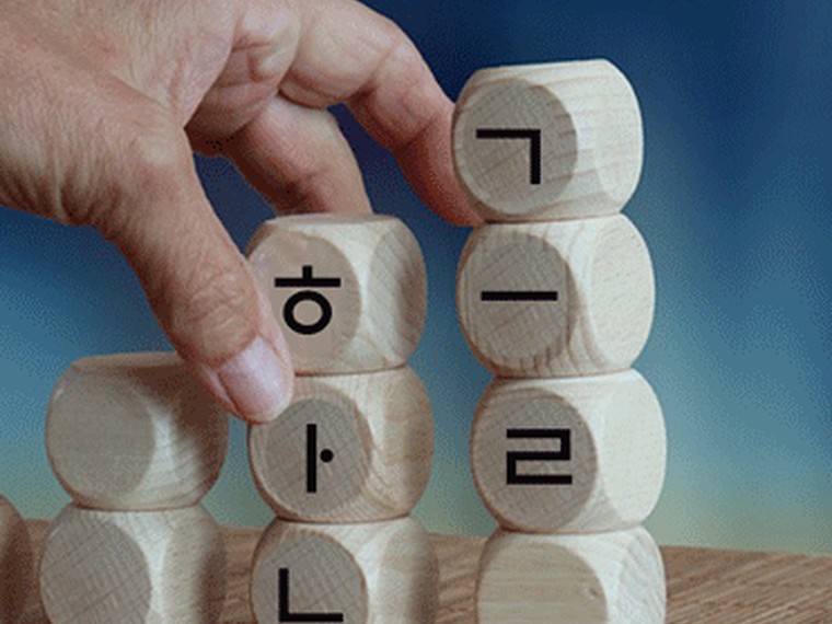 나무 블록으로 낱말을 쌓아 올리는 손