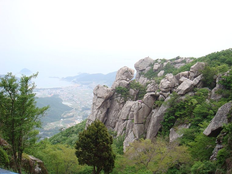 바위 능선 너머로 남해 바다가 펼쳐진 금산의 풍경